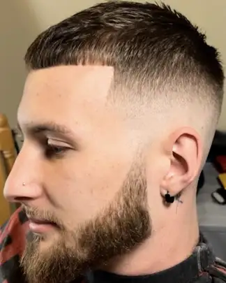 Skin fade blended into a shaped beard, cut at Studio K